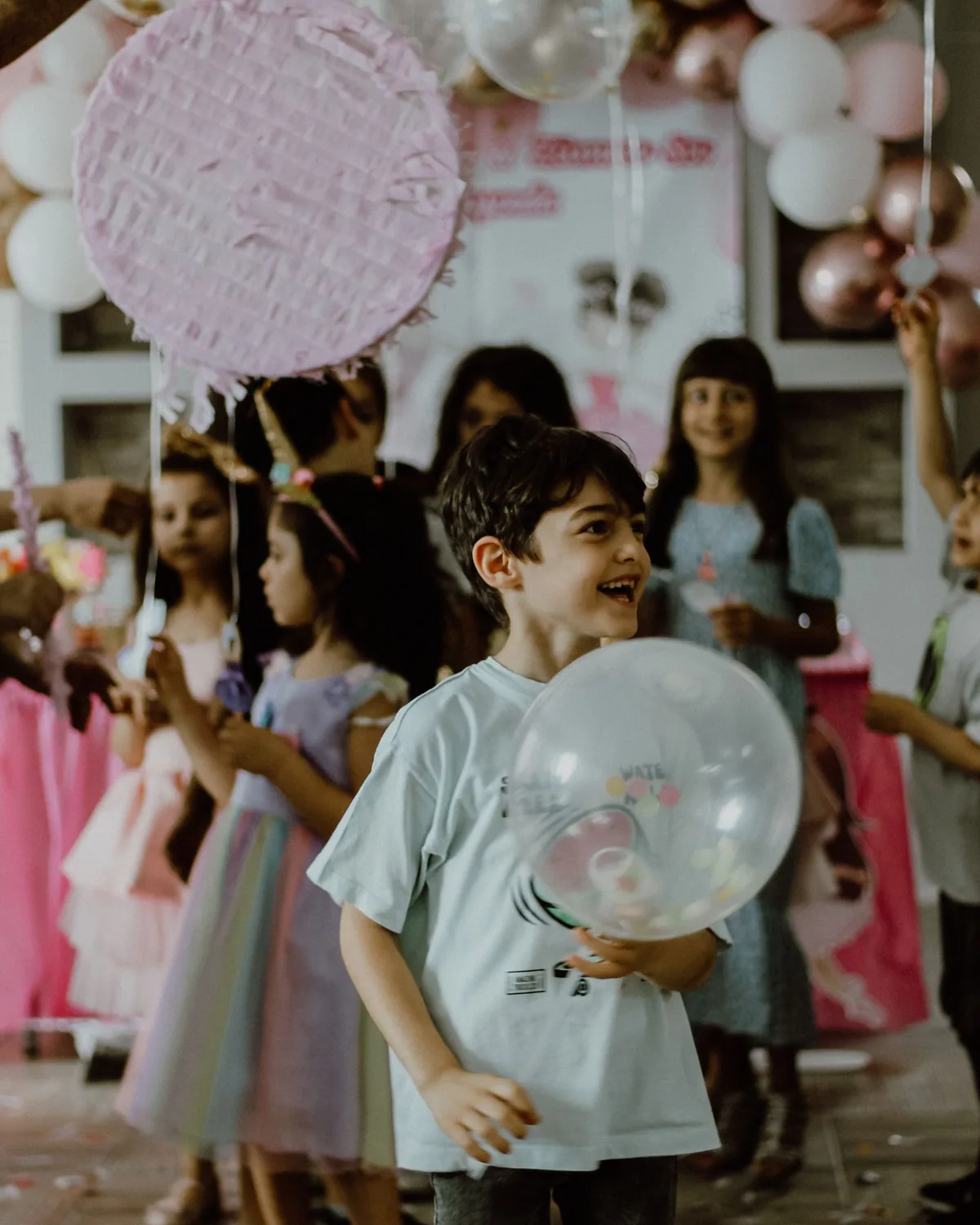 Children in party clothes playing with balloons at a celebration