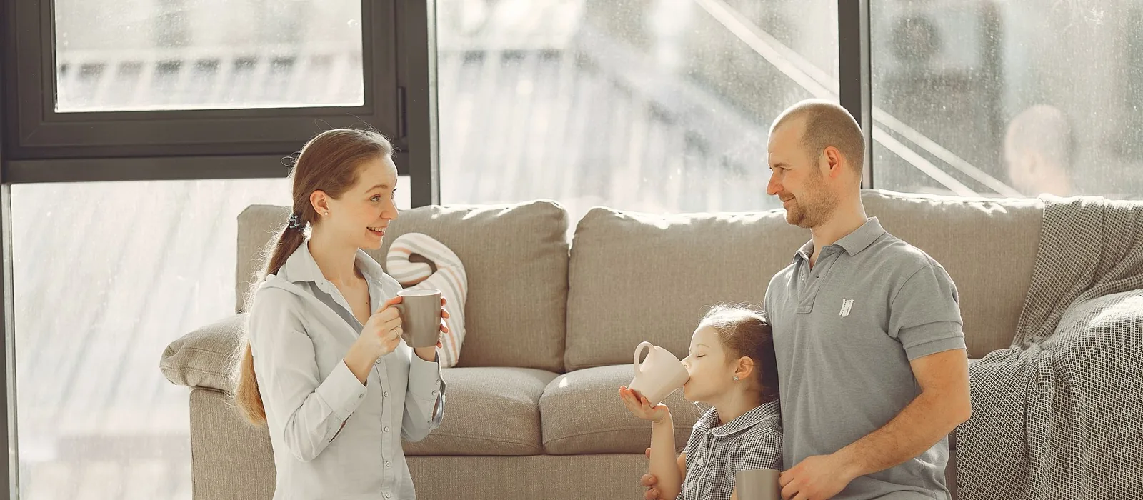 Two parents playing with their toddler on a rug at home