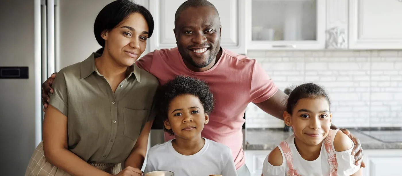 A family of four together in their kitchen