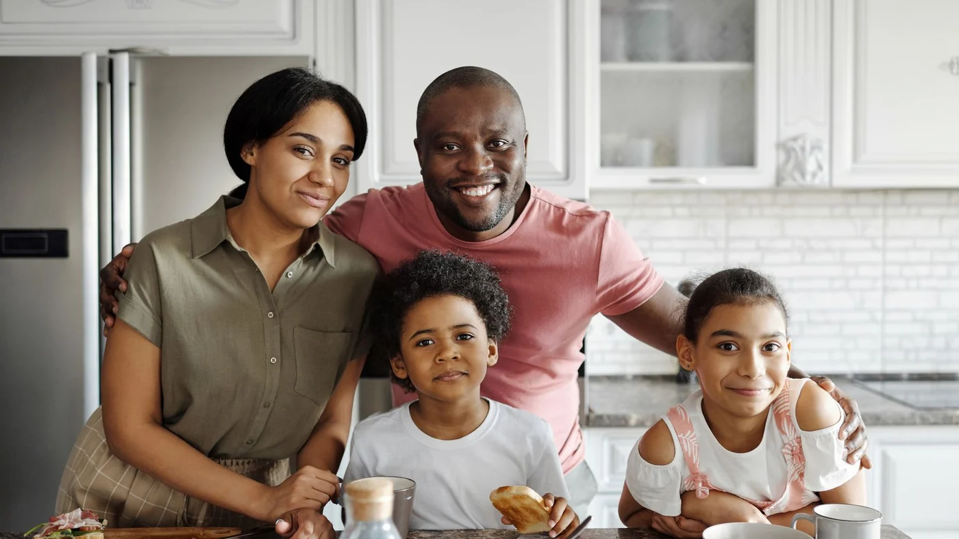 A family of four together in their kitchen